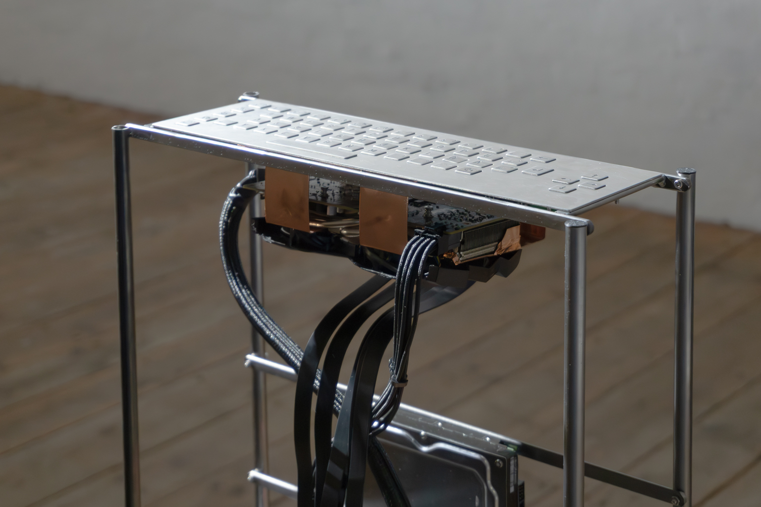 Clavier métallique de to hurt for a thought, relié par des pièces de cuivre au matériel informatique visible en dessous.