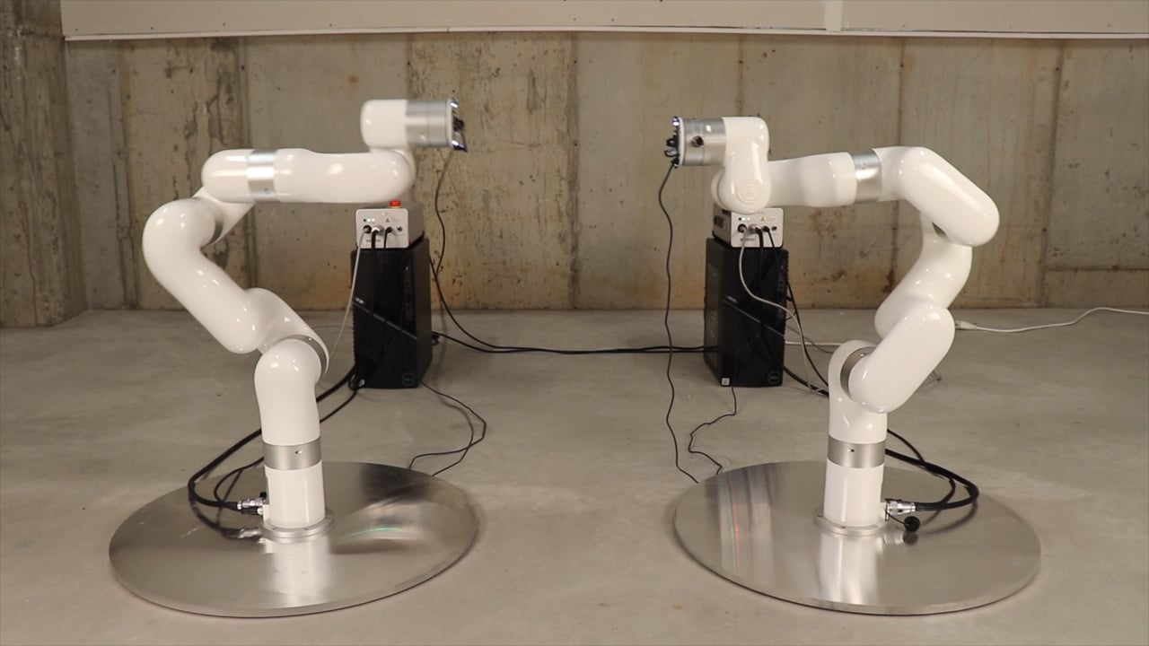 Deux bras robotisés blancs se font face.