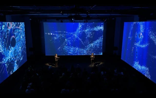 Projections bleues de The Thinking Ocean dans un espace immersif / Blue projections of The Thinking Ocean in an immersive space.