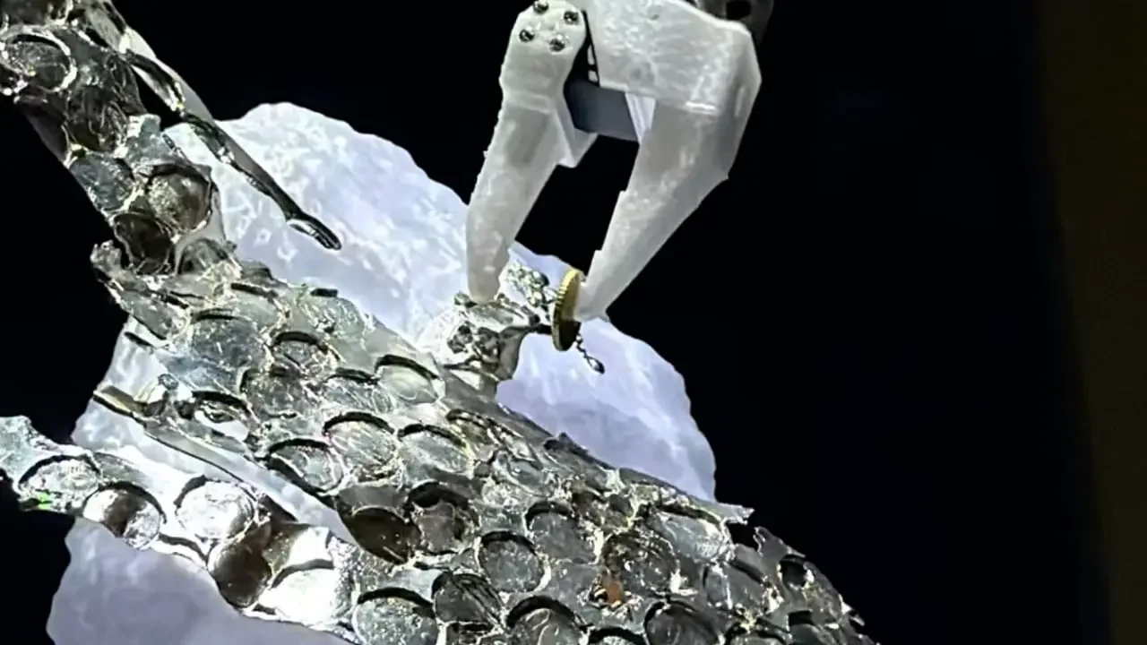 Sculpture robotique blanche se déplaçant sur une structure translucide au Fresnoy.