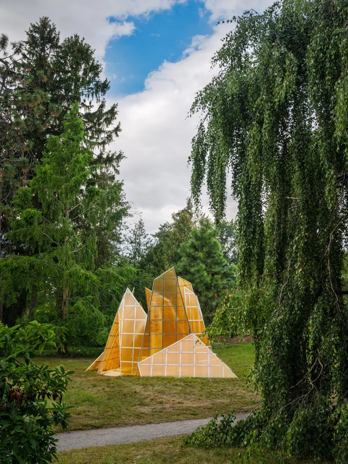 Une serre jaune fragmentée en pointes inégales au milieu d’un jardin : A Road Divided SSP4 de Bigert & Bergström.