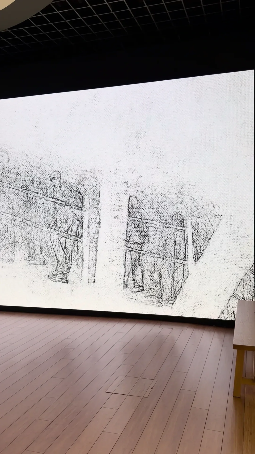 Des figures dessinées apparaissent sur une grande projection murale dans Traveler de Kakyoung Lee.