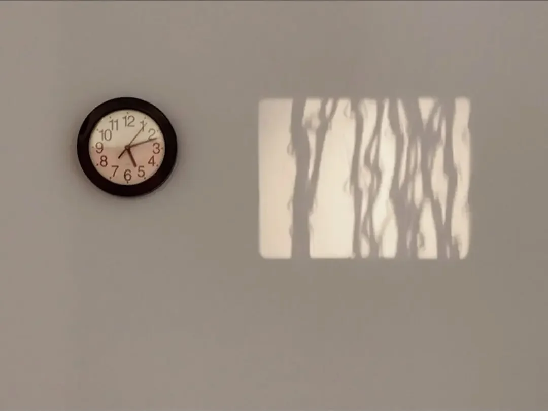 Ombres de fils projetées près d’une horloge pendant Untitled de Sofia Mastorakis.