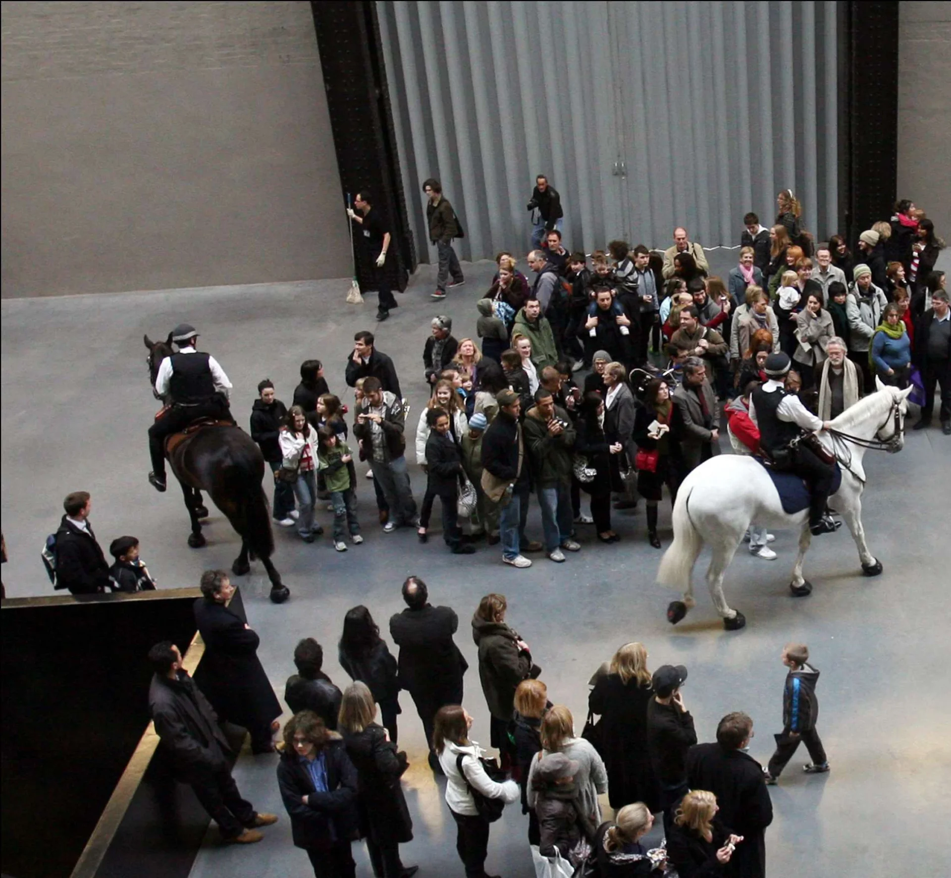 Deux policiers à cheval entourent les visiteurs de Tate Modern pendant Tatlin’s Whisper #5 de Tania Bruguera.